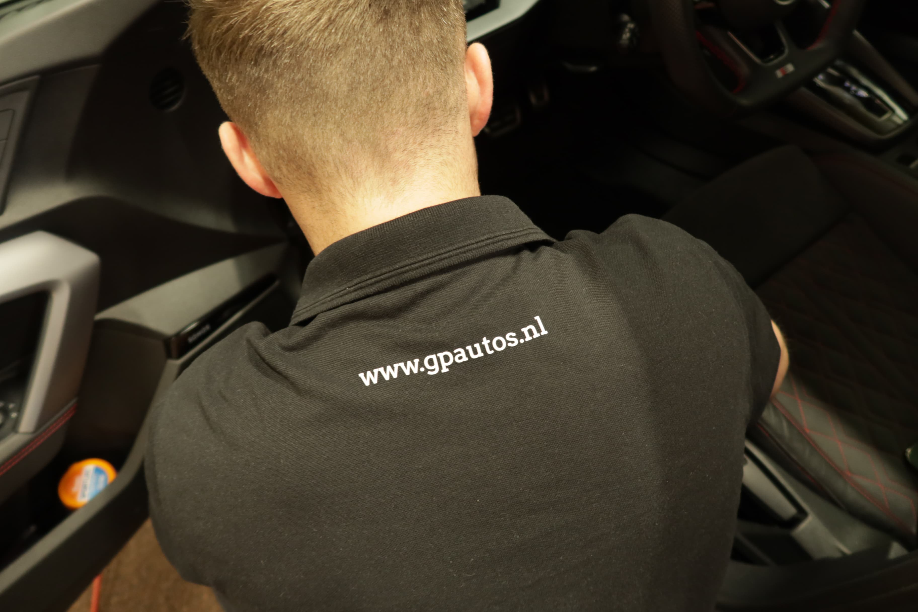 Een monteur van GP Auto's aan het werk in een auto
